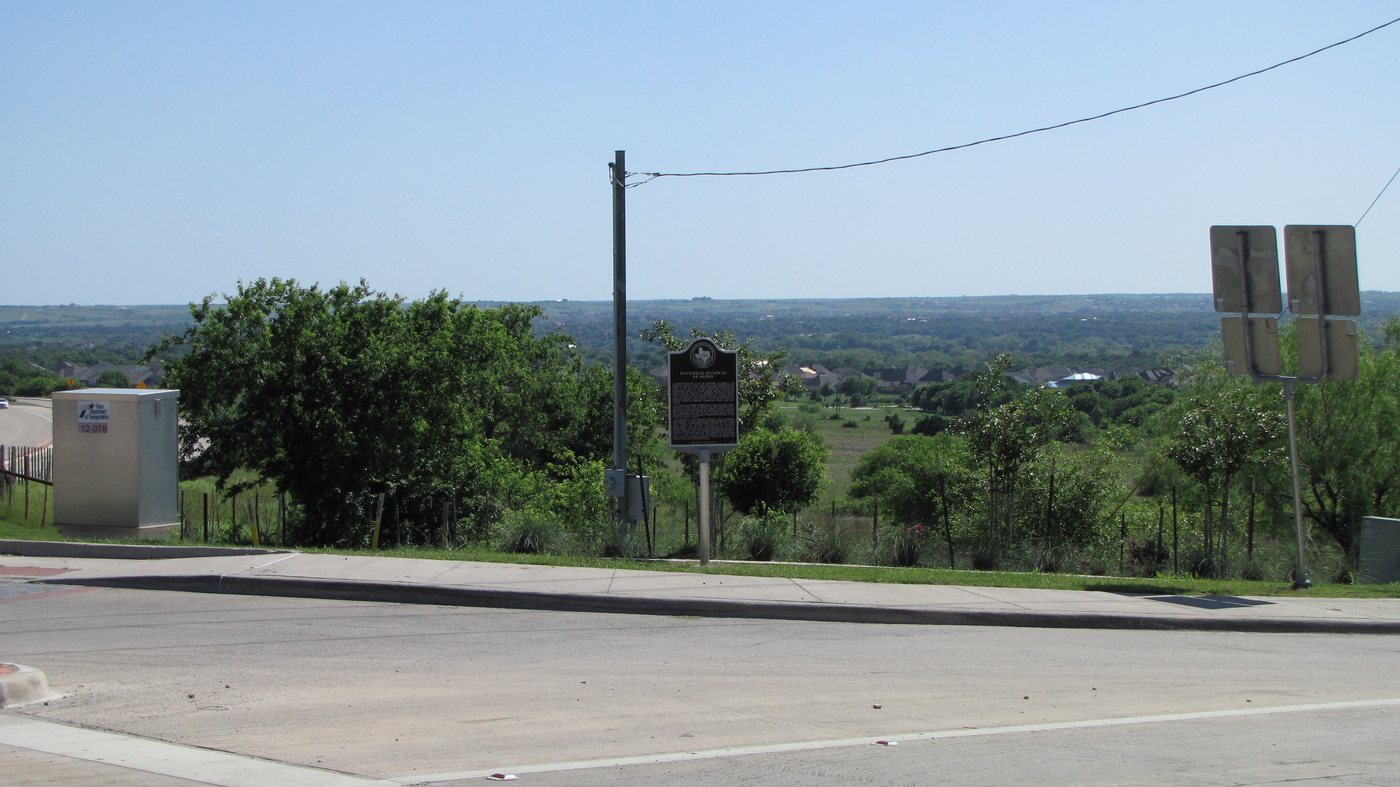 The Bankhead Highway historical marker in Aledo, Texas, a metal plaque on a post beside a roadway, photographed in daylight.